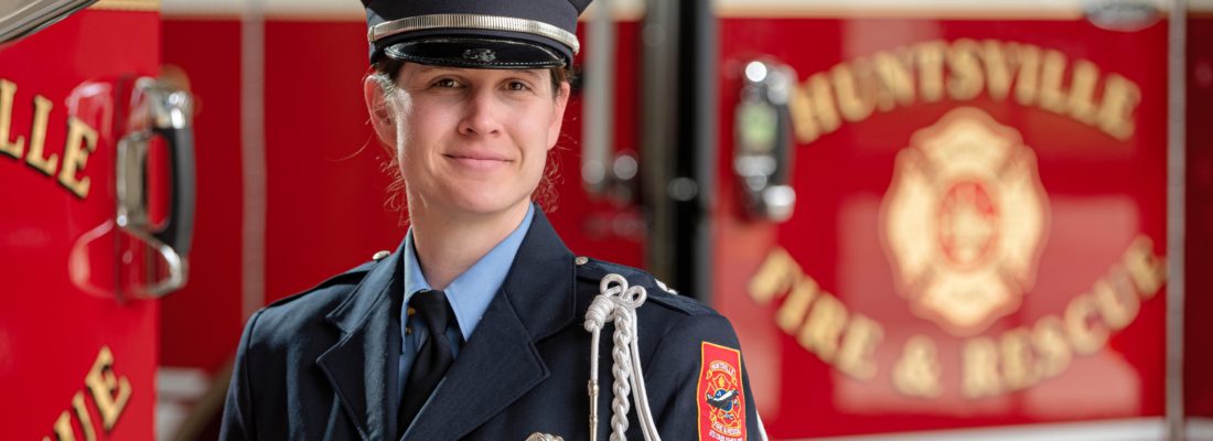 A photo of a female Huntsville Fire & Rescue team member in front of a fire truck