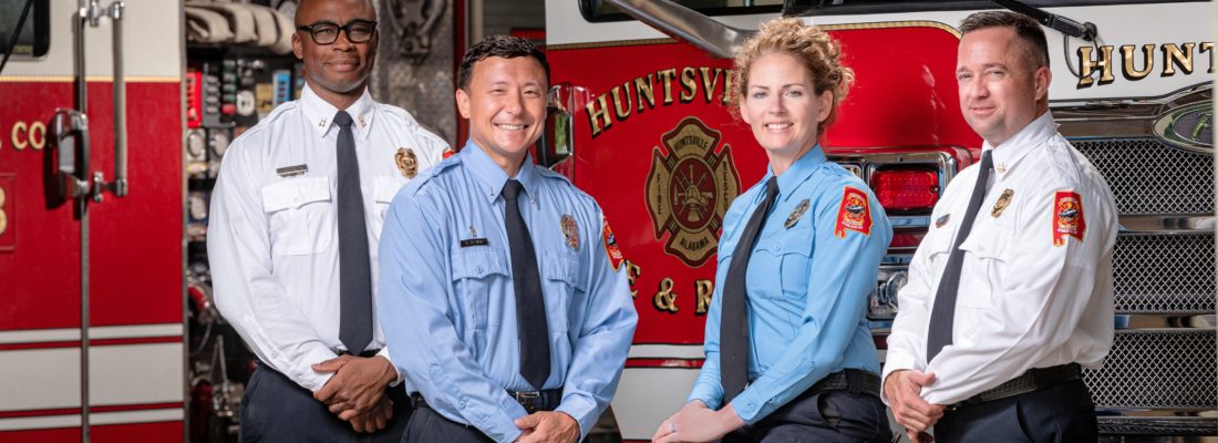 Huntsville Fire & Rescue team members take a photo in front of a fire truck